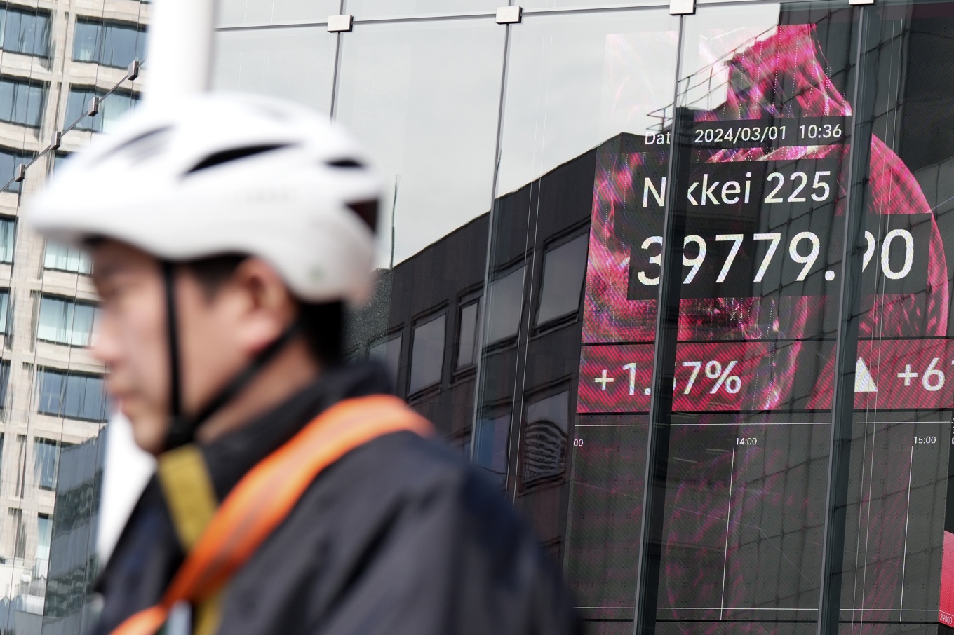 En person framför en skylt som visar börskursen för Nikkei 225. Arkivbild. Foto: Eugene Hoshiko/AP/TT