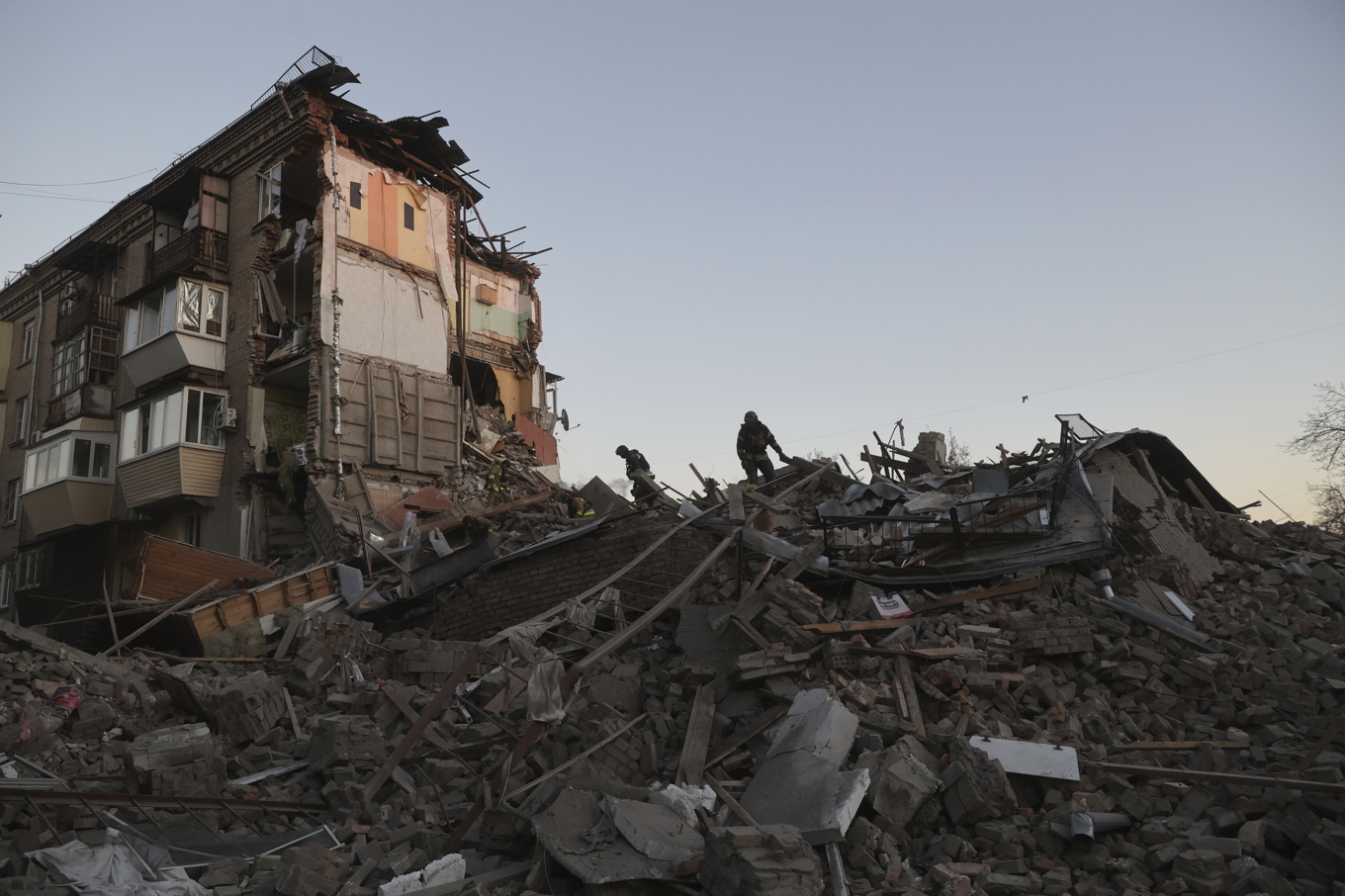 Räddningsarbetare jobbar i bråtet efter det att ett bostadshus träffats i en rysk attack under torsdagen. Foto: Kateryna Klochko/AP/TT
