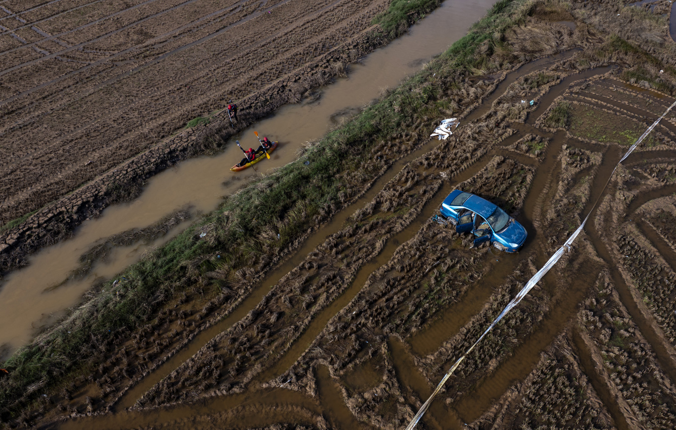 Räddningsarbetare i kanot söker efter döda i ett område i Valencias utkant. Bilden togs i fredags. Foto: Emilio Morenatti/AP/TT