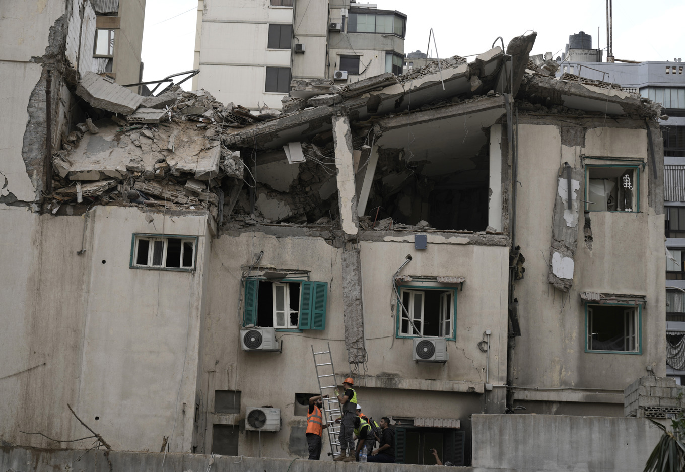 Räddningspersonal arbetar vid den träffade byggnaden i centrala Beirut. Foto: Bilal Hussein/AP/TT