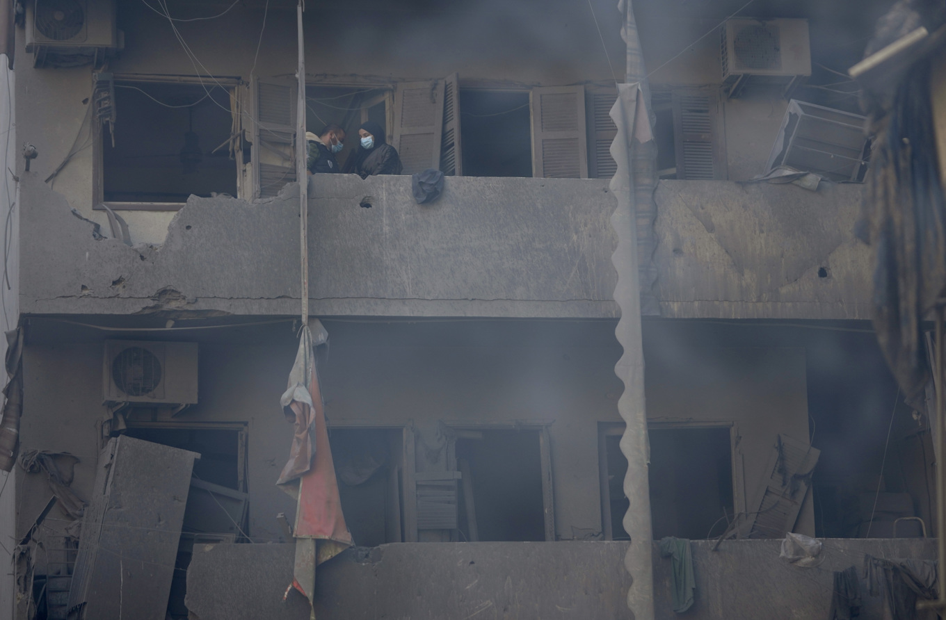 Beirutbor på sin förstörda balkong efter lördagens israeliska attack mot de centrala delarna av den libanesiska huvudstaden. Foto: Hussein Malla/AP/TT