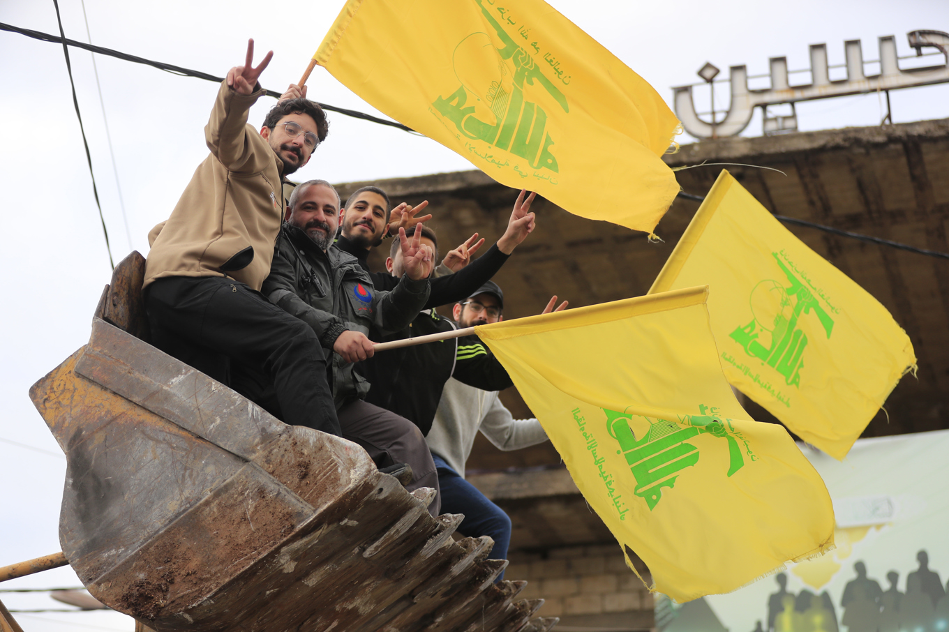 Män med Hizbollahflaggor firar sittande i en grävskopa sedan vapenvilan trätt i kraft på onsdagen. Foto: Mohammed Zaatari/AP/TT
