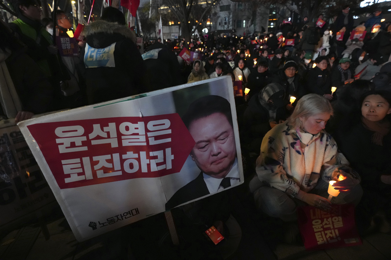 Demonstranter på Seouls gator kräver att president Yoon Suk-Yeol avgår efter beslutet i tisdags då han utlyste undantagstillstånd men tvingades dra tillbaka det bara sex timmar senare sedan parlamentet gått emot honom. Foto: Lee Jin-man/AP/TT