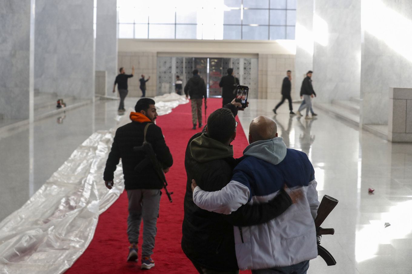 Två personer tar en selfie inne i presidentpalatset på söndagen. Foto: Omar Sanadiki/AP/TT