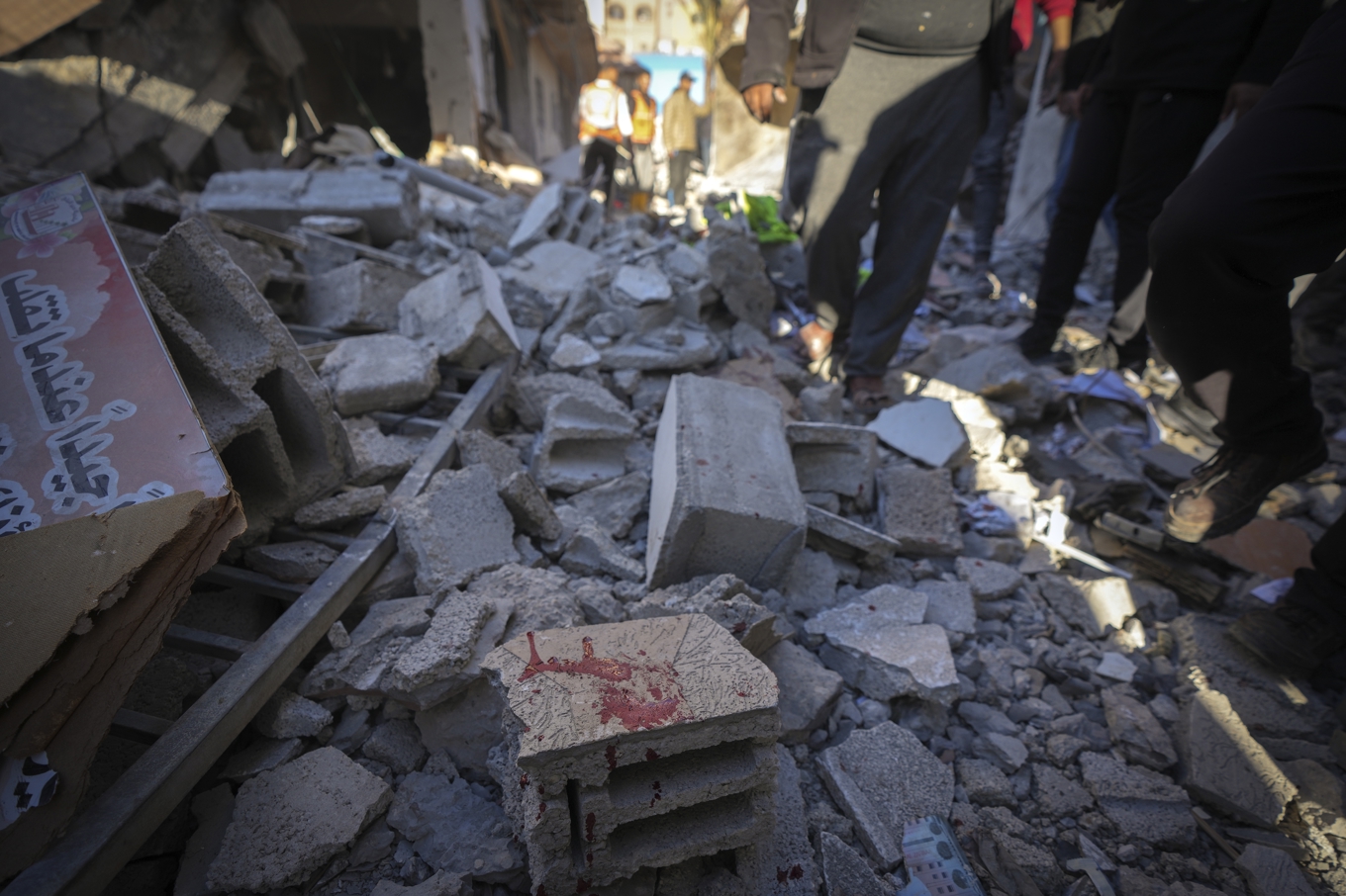 En blodfläck syns bland spillrorna av en byggnad som träffades i ett israeliskt flyganfall i Deir al-Balah under lördagen. Foto: Abdel Kareem Hana/AP/TT