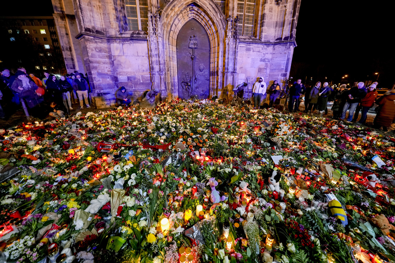 Människor har lämnat blommor och ljus framför Johanniskyrkan nära julmarknaden i Magdeburg, Tyskland. Bild tagen under lördagen. Foto: Michael Probst/AP/TT