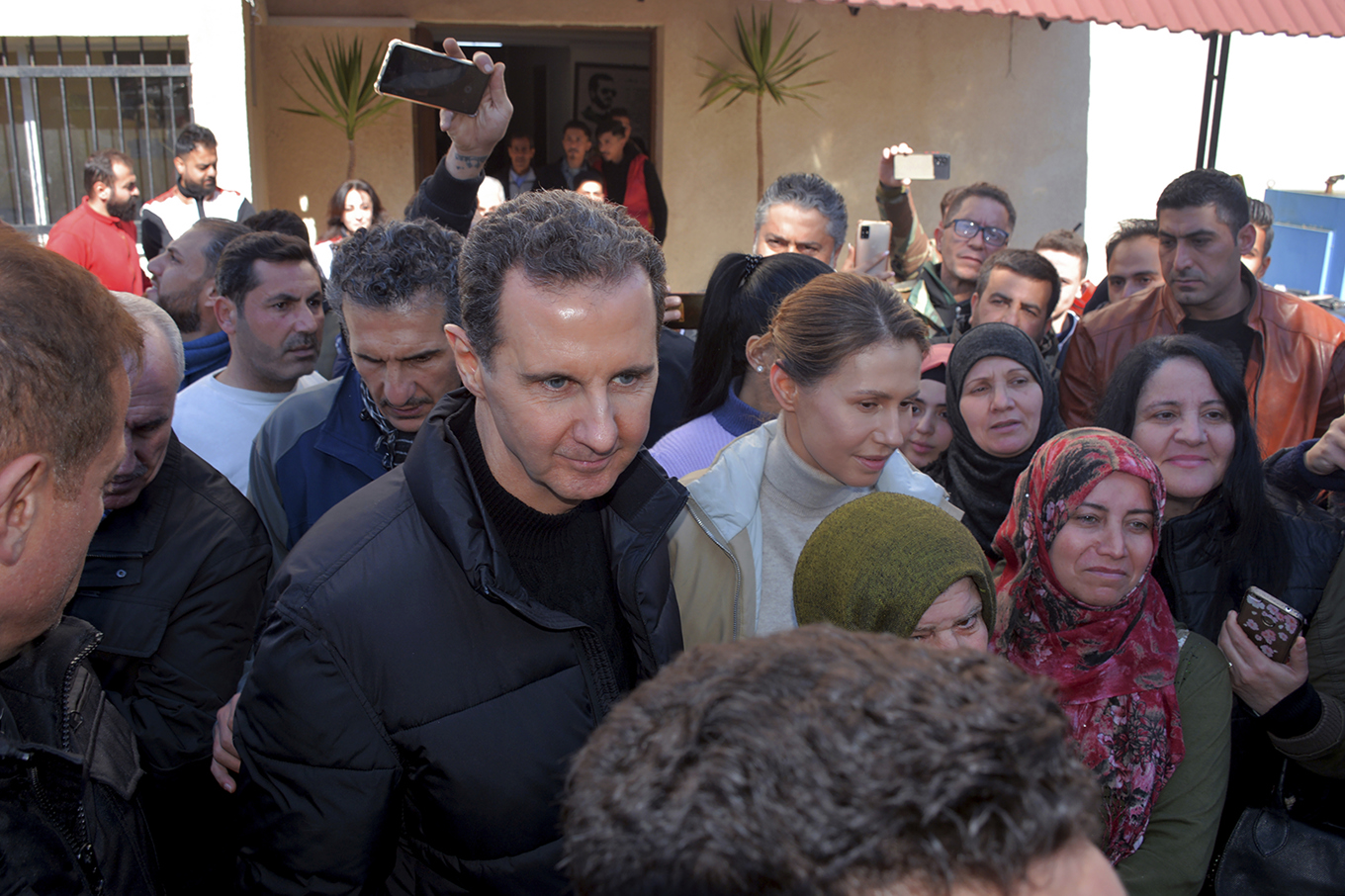 Bashar och Asma al-Assad, i mitten, vid ett besök i ett jordbävningsdrabbat område i västra Syrien förra året. Foto: Sana via AP/TT