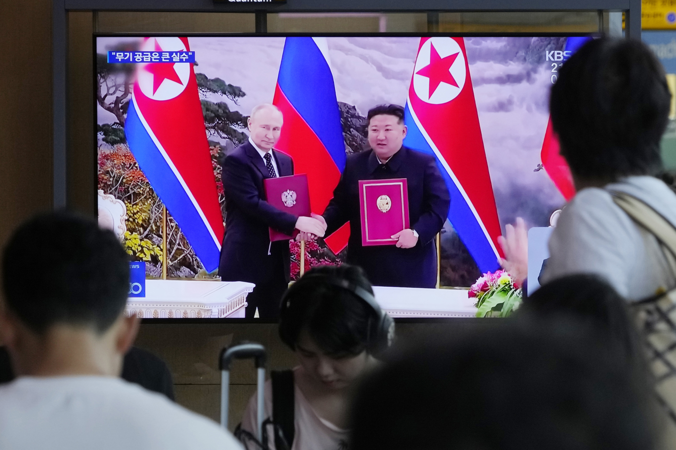 En tv visar bilder från Vladimir Putin och Kim Jong Uns möte i Pyongyang i juni. Arkivbild. Foto: Ahn Young-joon/AP/TT