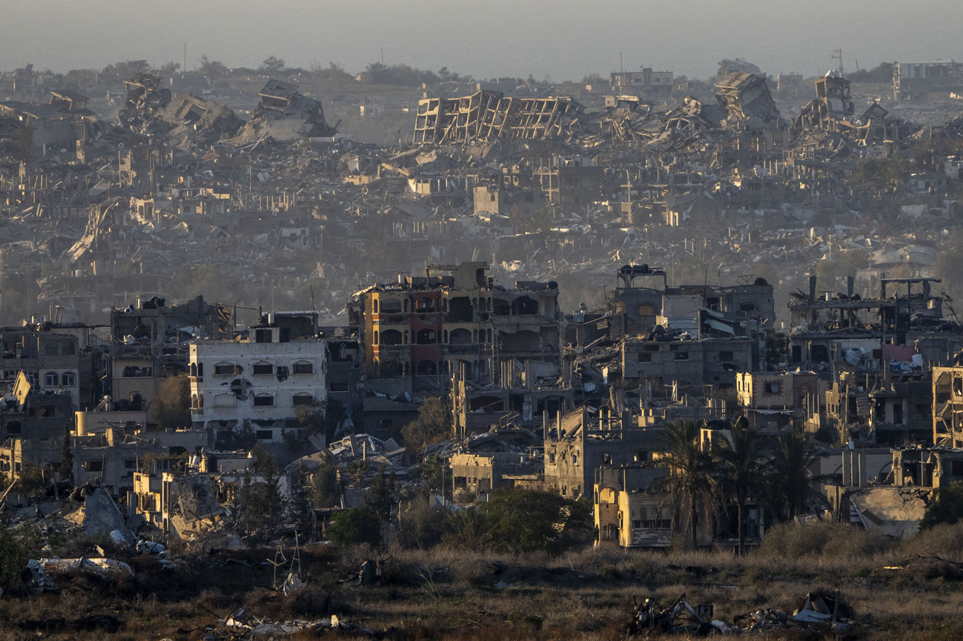 Förstörda byggnader i Gaza, här sett från södra Israel. Foto: Ariel Schalit/AP/TT