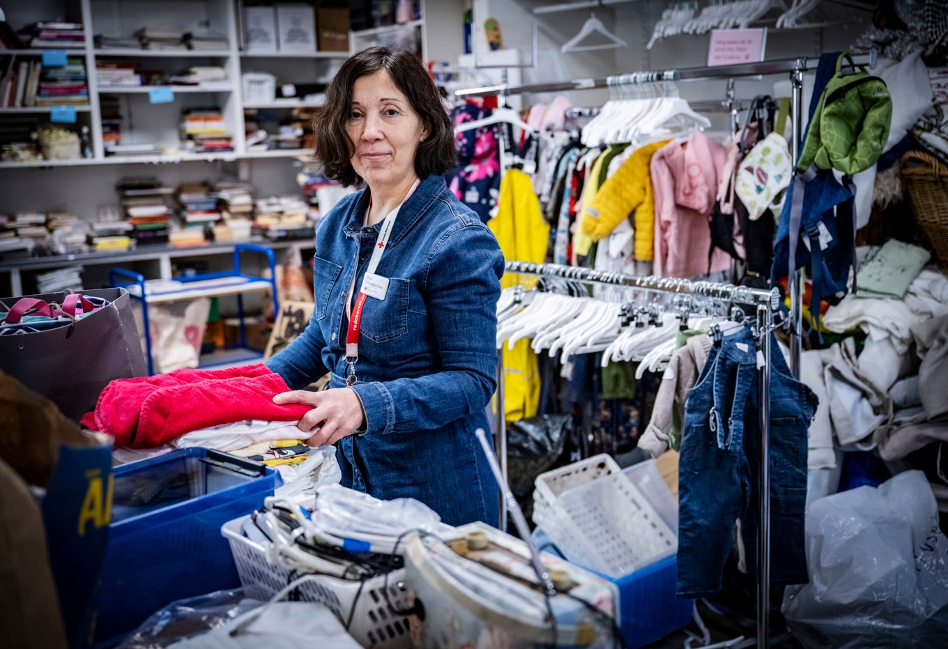 Else Österberg, föreståndare i Röda Korsets butik på Norra Parkgatan i Malmö, sorterar textilier och kläder som lämnats in för återbruk. Foto: Johan Nilsson/TT