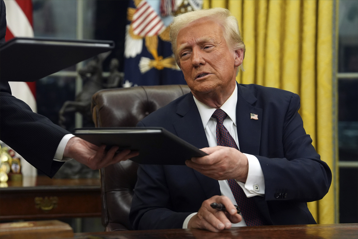 President Donald Trump skriver under en drös ordrar i Ovala rummet i Vita huset. Foto: Evan Vucci/AP/TT