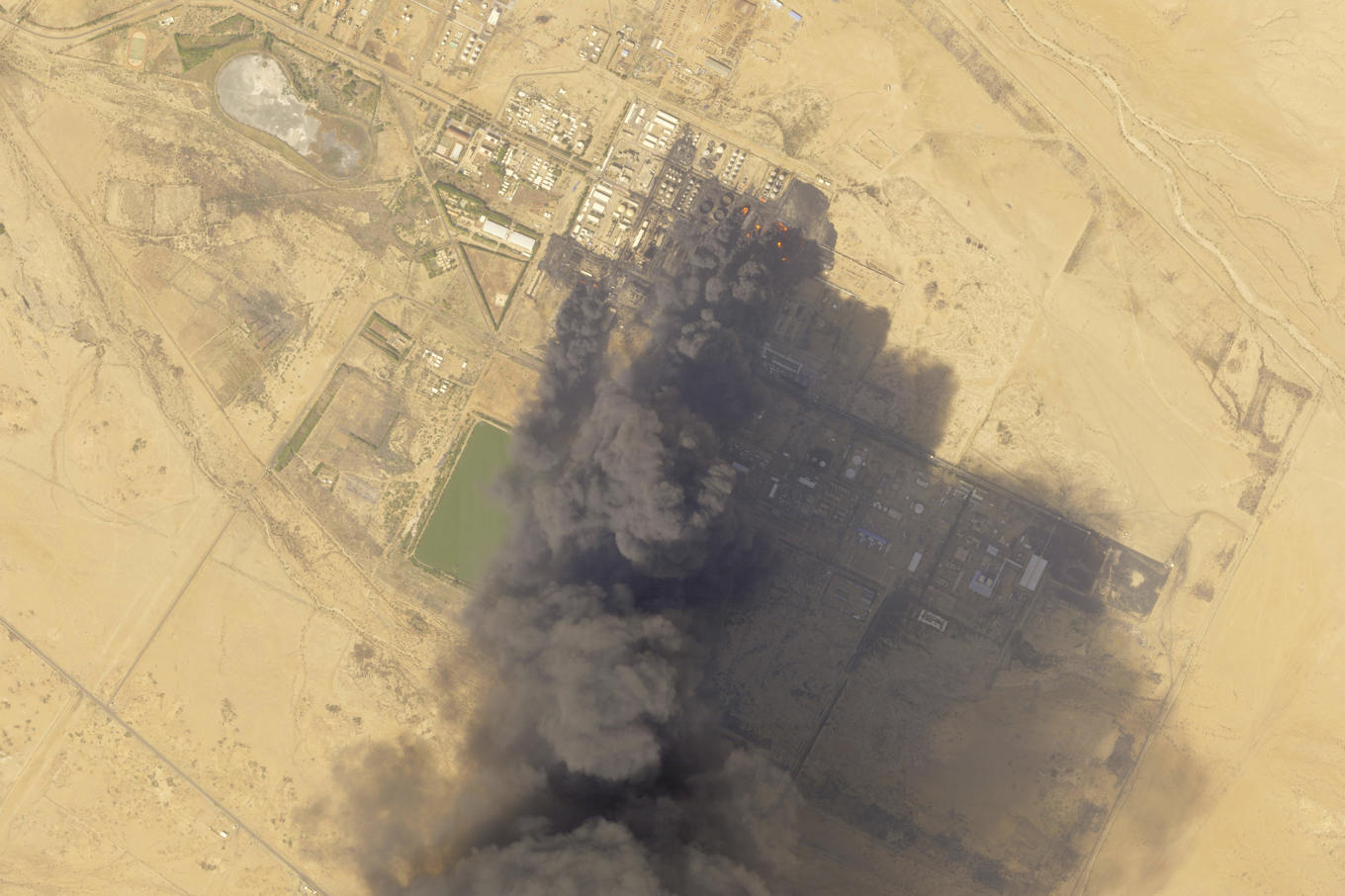 Tjock svart rök stiger från Sudans största oljeraffinaderi, norr om Khartoum, på fredagen. Foto: Planet Labs PBC via AP/TT