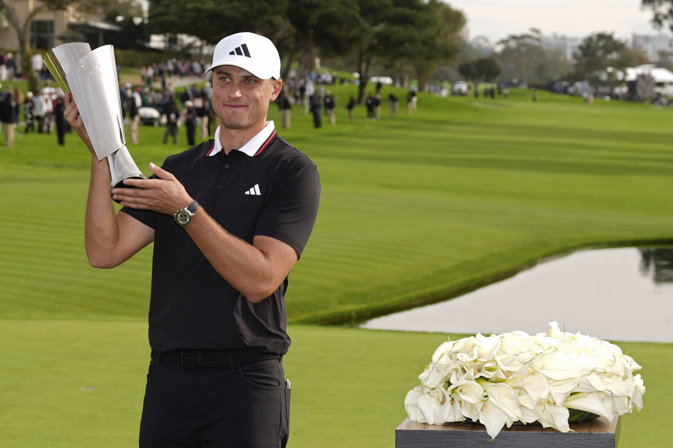 Ludvig Åberg med bucklan efter segern i stortävlingen på PGA-touren under söndagseftermiddagen. Sedan väntade simulatorgolf i inomhusligan TGL. Foto: Gregory Bull/AP/TT