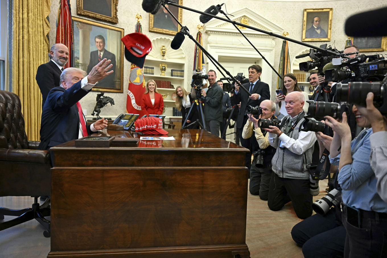 President Donald Trump kastar en keps med texten "Trump hade rätt om allt" medan han talar till reportrar i Ovala rummet i Vita huset på tisdagen. Foto: Pool via AP/TT