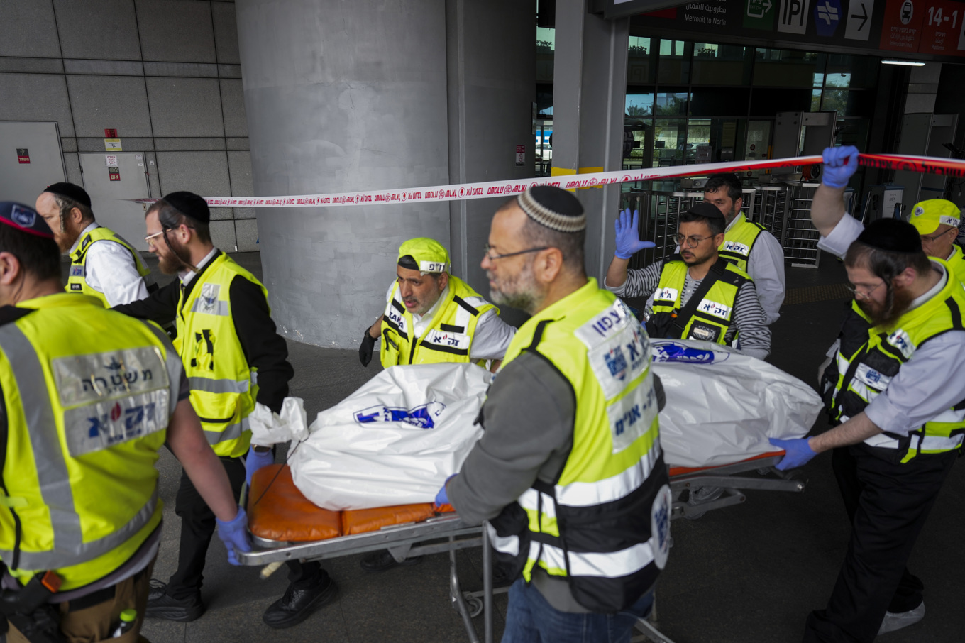 Räddningstjänst bär bort den 70-åring som dödades i attacken i Haifa på måndagen. Foto: Ariel Schalit/AP/TT