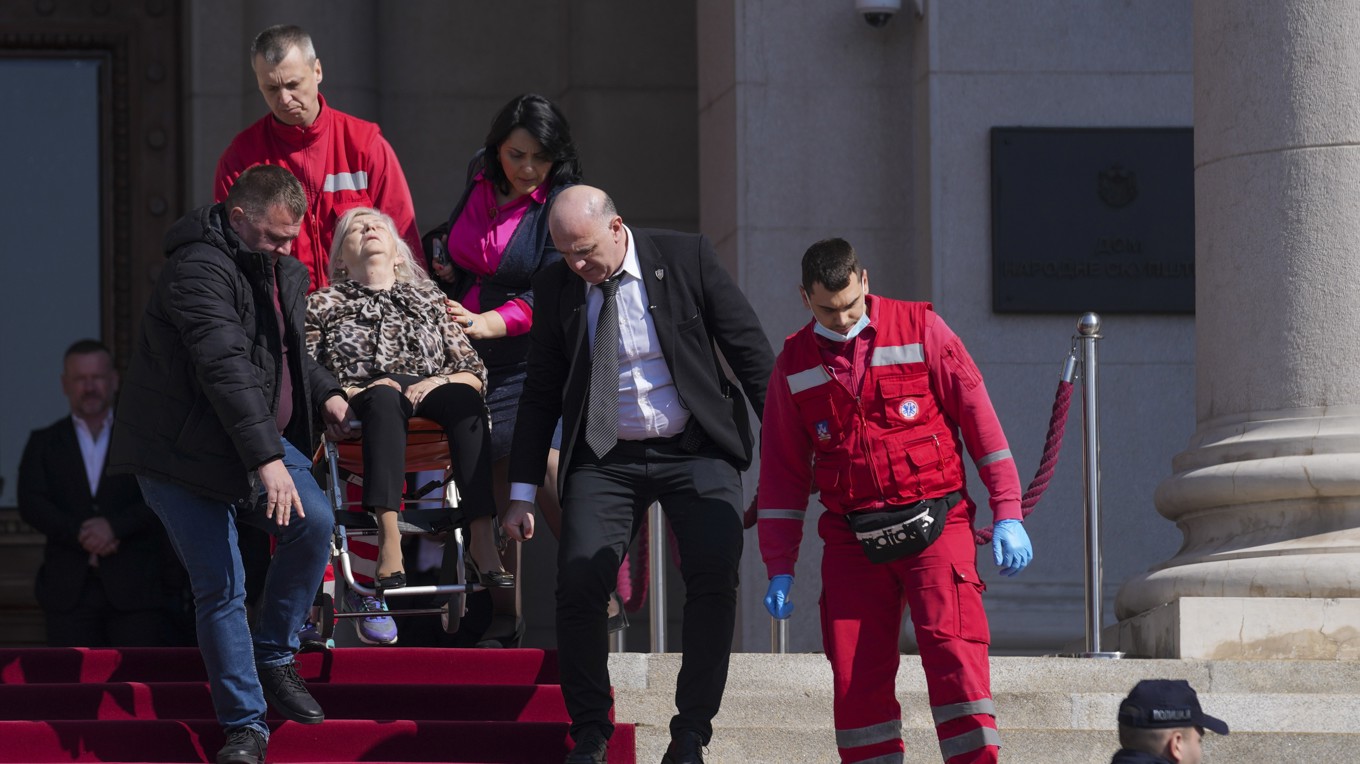 En skadad förs till vård efter kaoset i parlamentet. Foto: Darko Vojinovic/AP/TT
