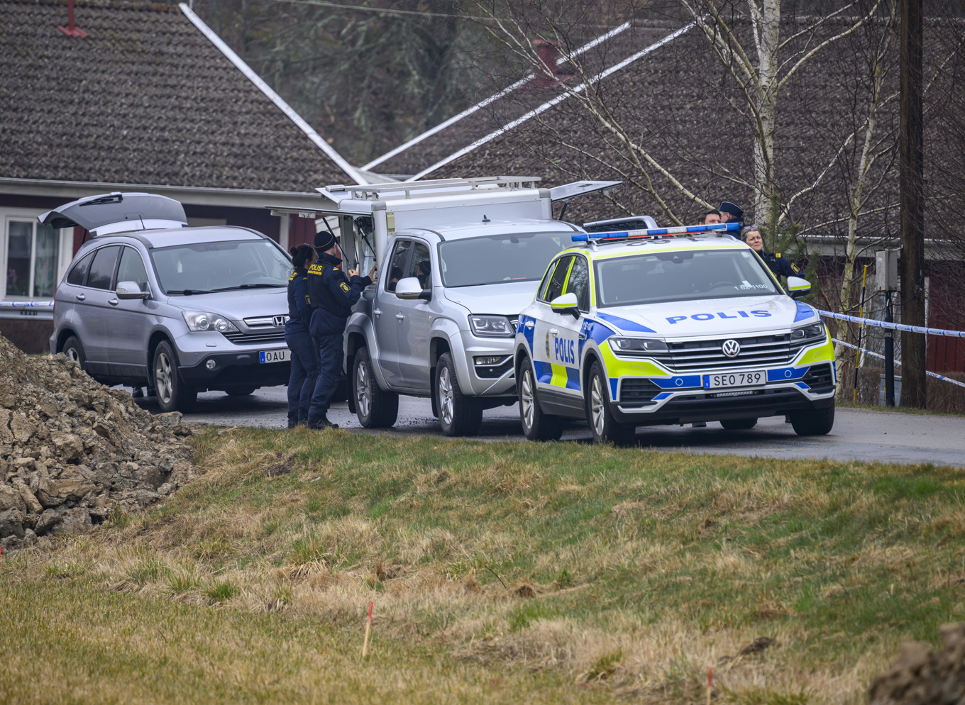Polis med drönare och kriminaltekniker på plats innanför avspärrningarna i ett samhälle utanför Karlshamn på tisdagen efter att polis skjutit verkanseld i samband med ett utredningsärende. Foto: Johan Nilsson/TT