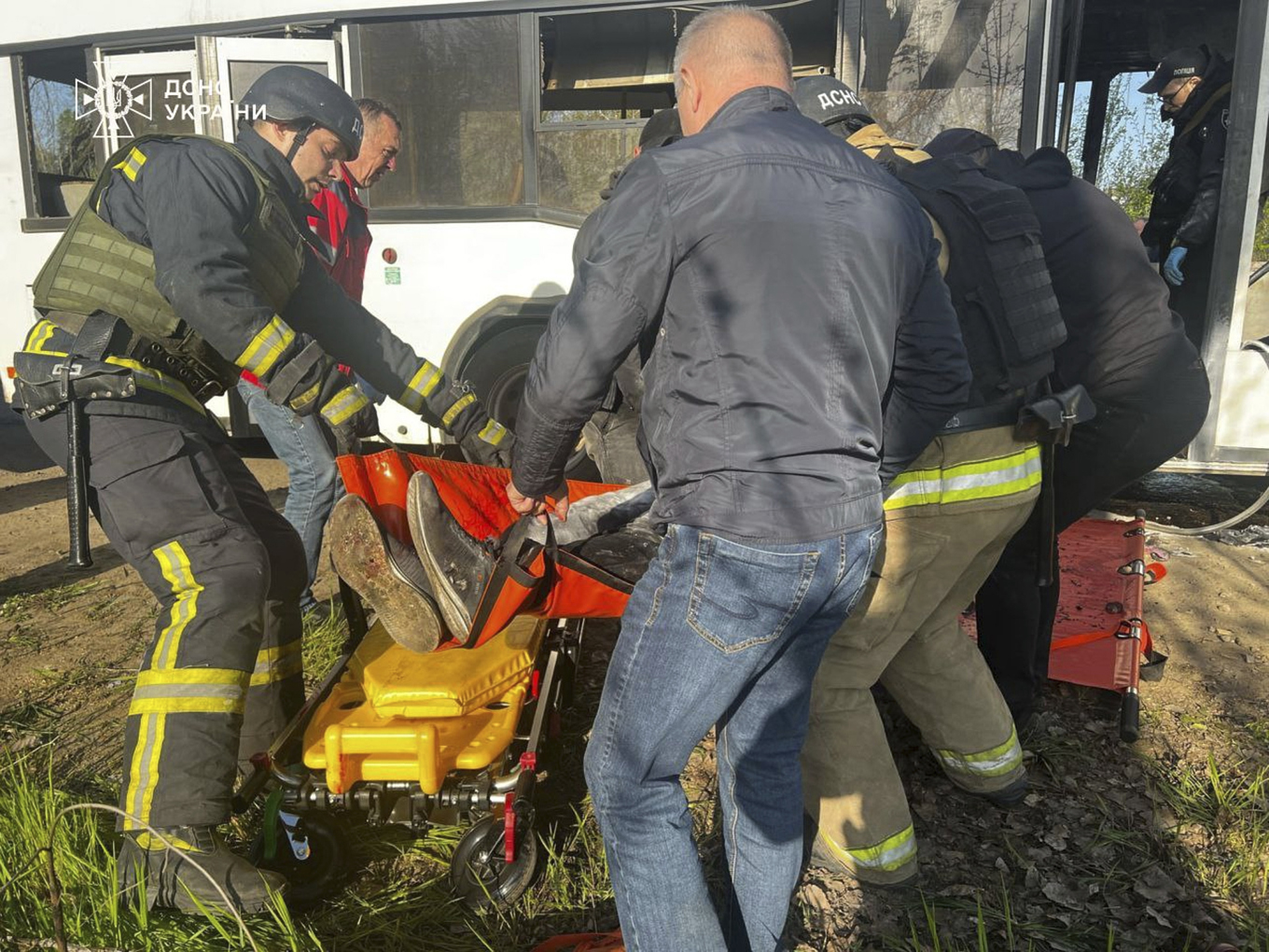 Drabbade personer bärs ut från den bombade bussen i Marhanets, på en bild som har distribuerats av den ukrainska räddningstjänsten. Foto: Ukrainsk räddningstjänst via AP/TT