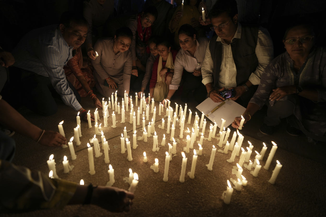 Människor placerar ut ljus efter en protest mot tisdagens dåd nära turistorten Pahalgam i indiska Kashmir. Foto: Ajit Solanki/AP/TT