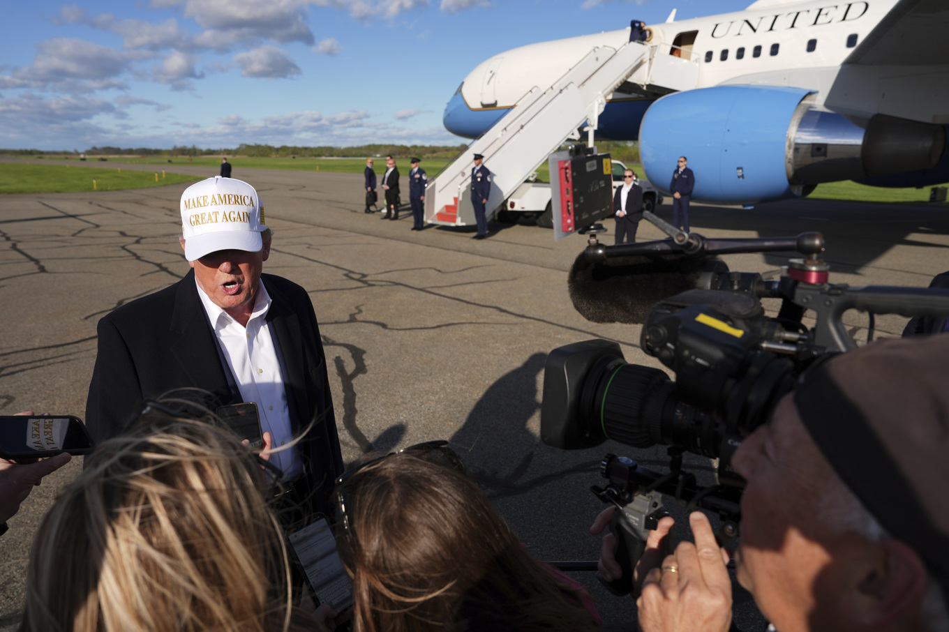 Donlad Trump svarar på frågor från reportrar i samband med att han ska gå ombord presidentflyget Air Force One på söndagen. Foto: Evan Vucci/AP/TT