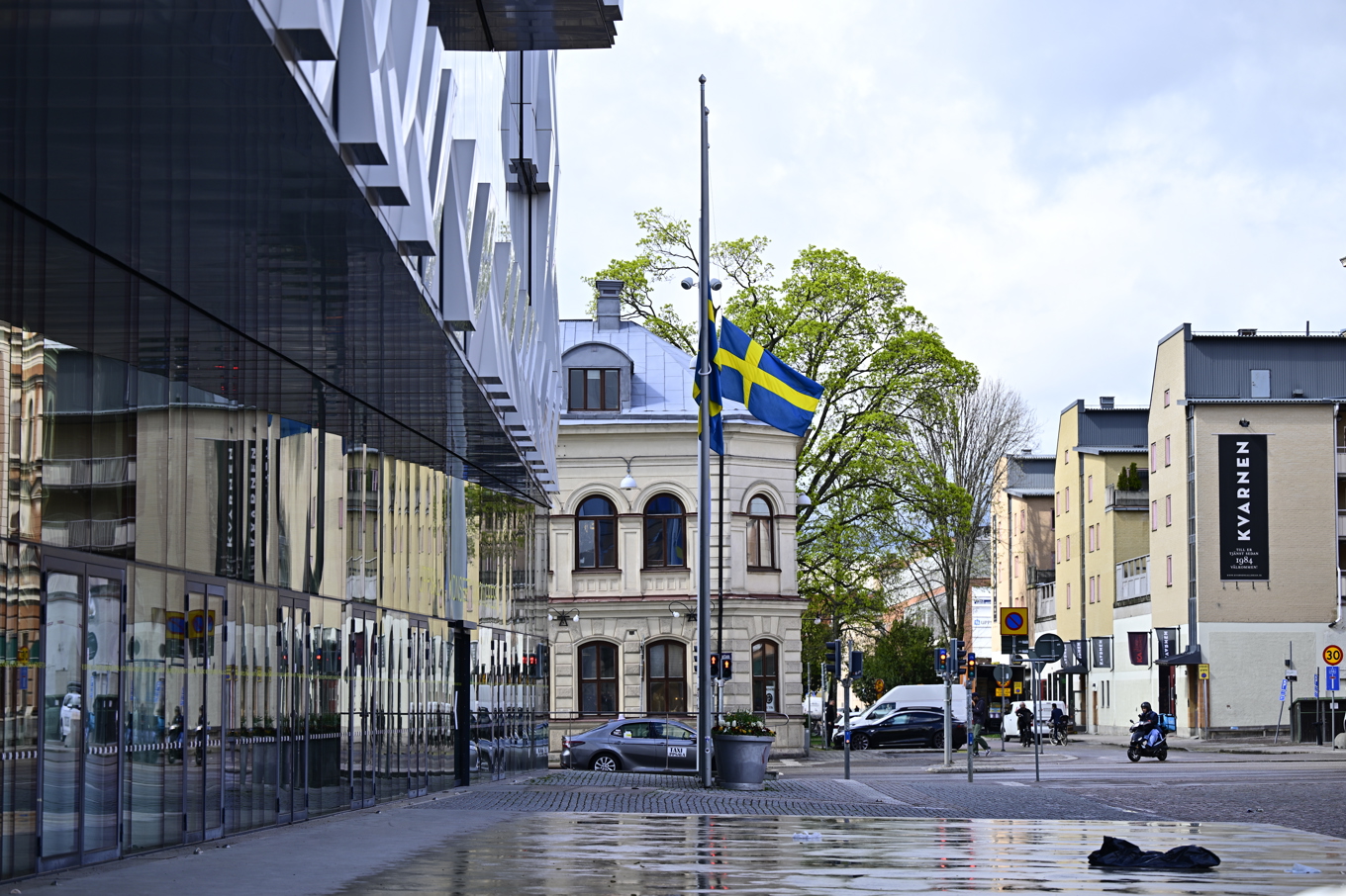 Svenska flaggan vajar på halv stång vid Uppsalas konsert- och kongresshall på Vaksala torg, tre dagar efter trippelmordet på en frisersalong i närheten Foto: Magnus Lejhall/TT