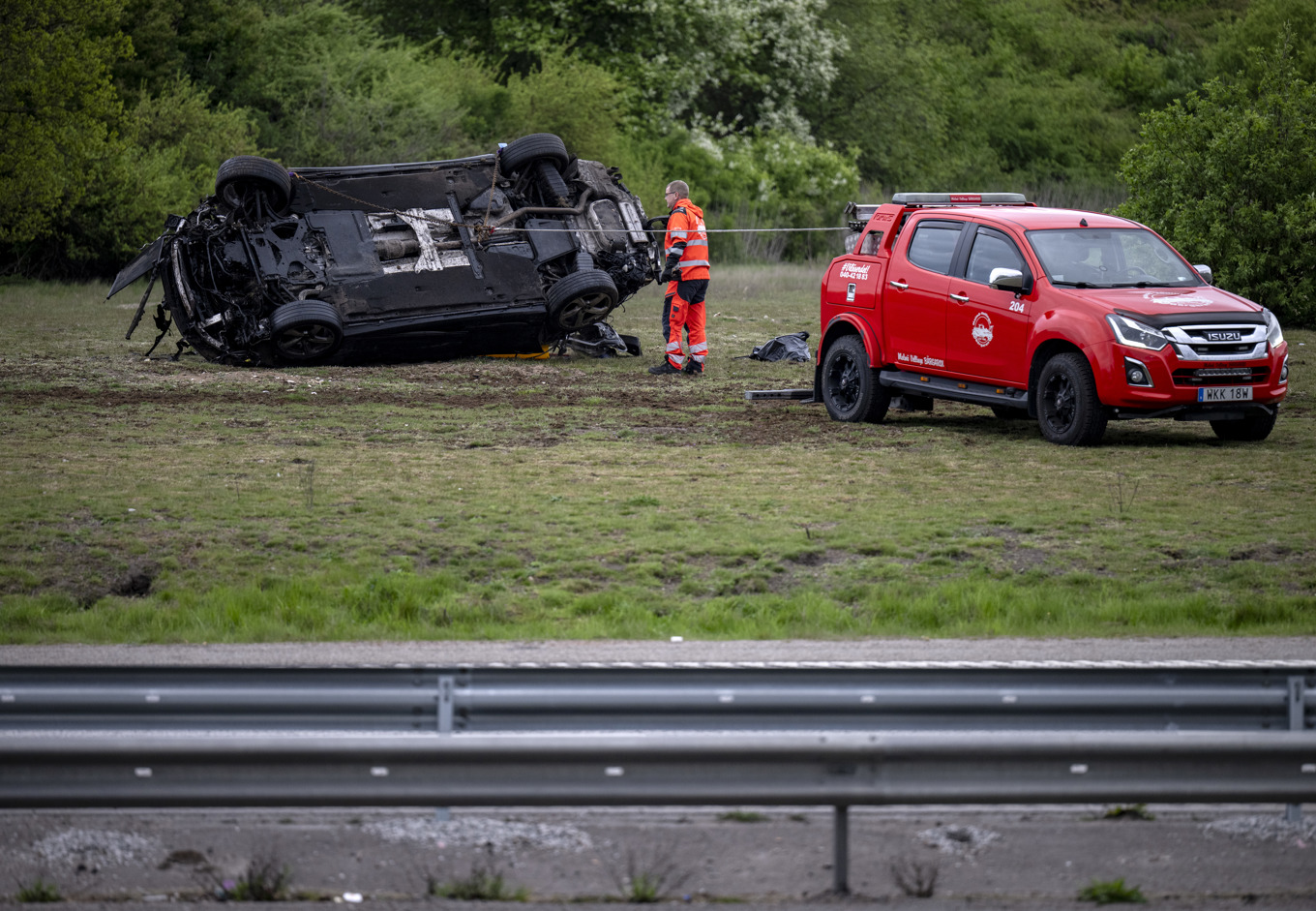 Bärgare på plats efter att en bil voltat av vägen i nordöstra Malmö tidigt på lördagsmorgonen. Fyra personer har förts till sjukhus. Foto: Johan Nilsson / TT