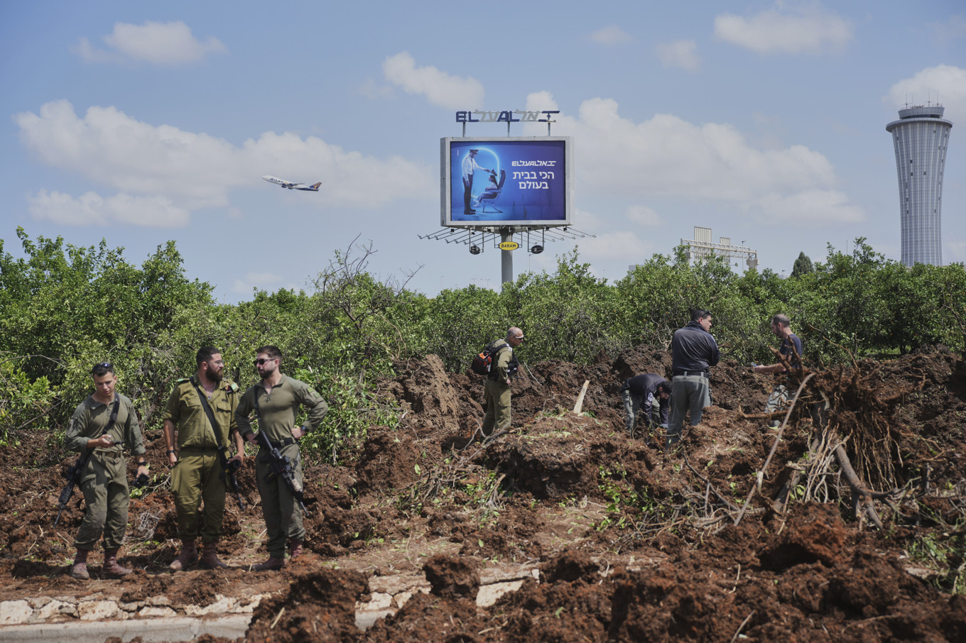 Israeliska säkerhetsstyrkor inspekterar området där en robot slog ned nära Israels största flygplats på söndagen. Foto: Ohad Zwigenberg/AP/TT