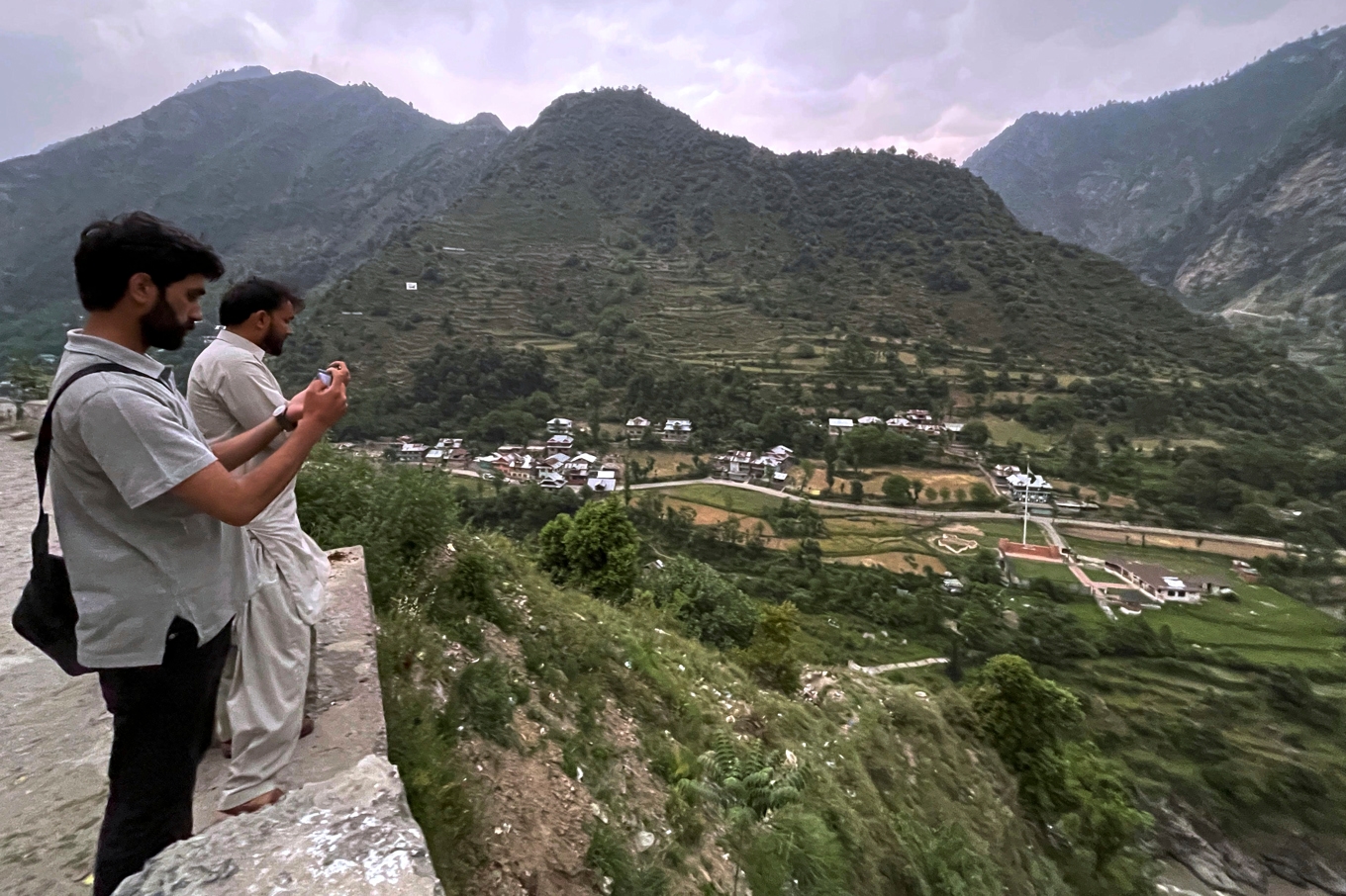 Lokalbefolkning tar bilder över den indiska delen av Kashmir från den pakistanskkontrollerade sidan av området. Bild från 1 maj. Foto: M.D. Mughal/AP/TT