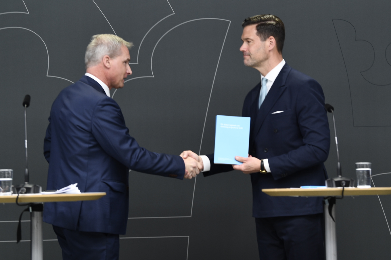 Chefsåklagaren Ola Sjöstrand lämnar över förslag om skärpta regler för brottsutvisningar till migrationsminister Johan Forssell. Foto: Lars Schröder/TT