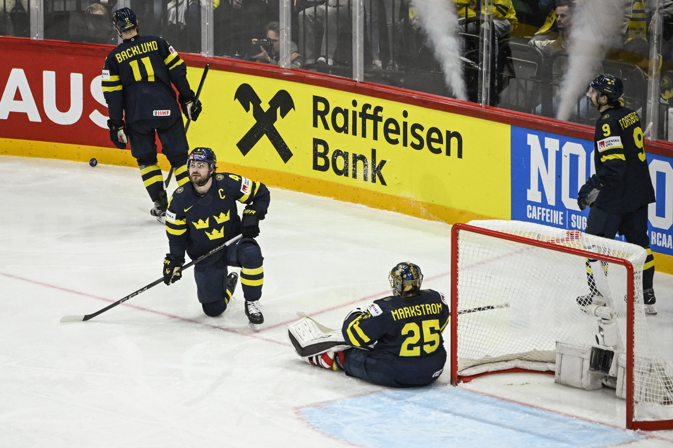 Sveriges målvakt Jacob Markström och lagkaptenen Rasmus Andersson, på ett knä, deppar efter Kanadas femte mål. Foto: Fredrik Sandberg/TT