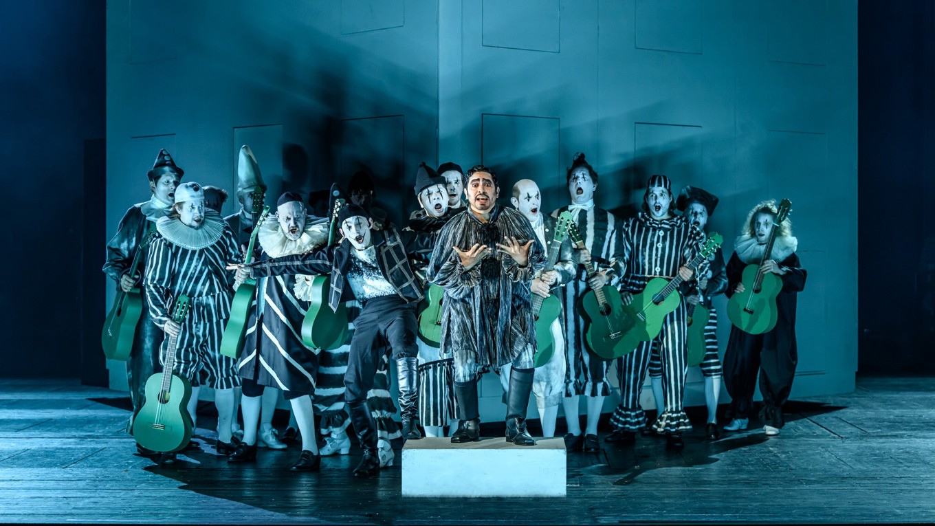 César Cortés som greve Almaviva, och Kungliga Operans herrkör, framför första scenens enda dekoration, det vita lådhuset. Foto: Sören Vilks