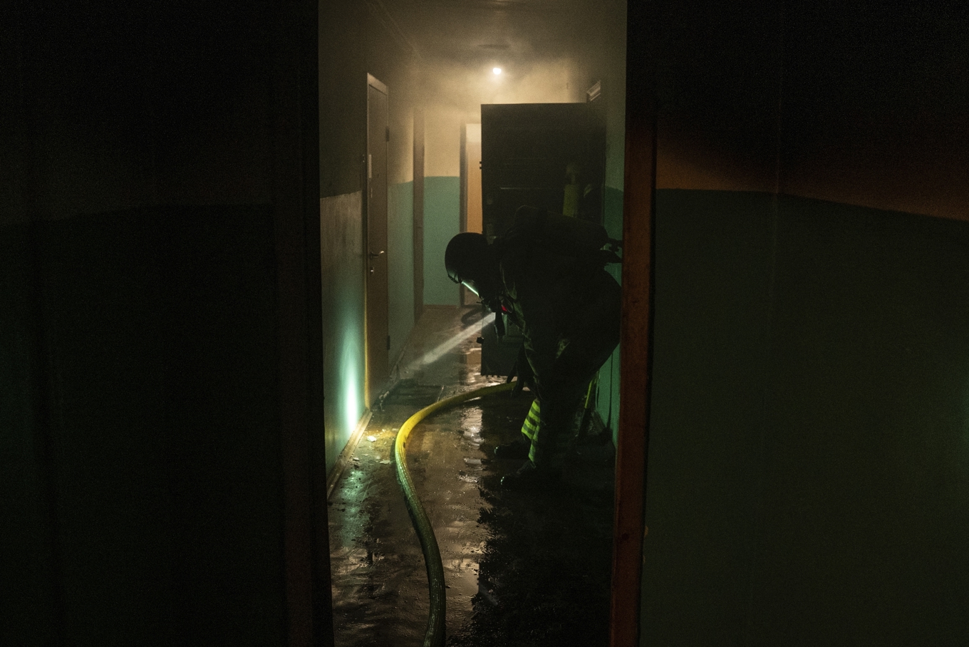 Brandmän arbetar i ett skadat bostadshus efter en rysk attack mot Kiev natten till lördag. Foto: Alex Babenko/AP/TT