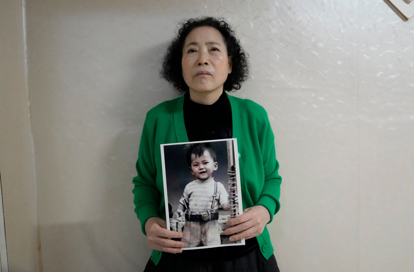 Choi Young-Ja med en bild på sonen som försvann 1975. Nästan 50 år senare fick hon veta att han adopterats bort till Norge. Foto: Ahn Young-Joon/AP/TT