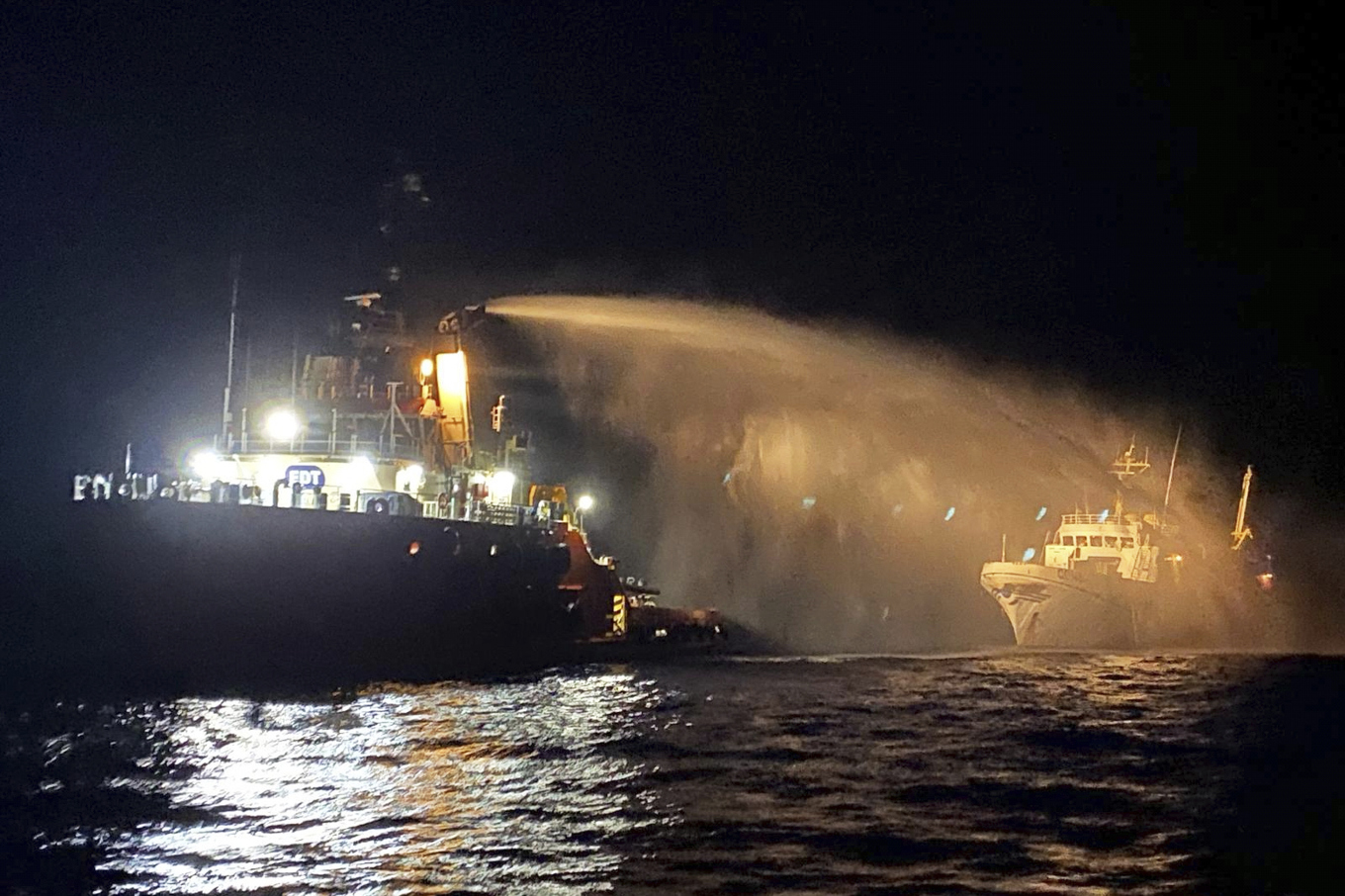 En bogserbåt med brandbekämpningsutrustning kom Conscience till undsättning. I fartygets främre skrov syns ett hål. Foto: Malta Vessel Traffic Services via AP/TT