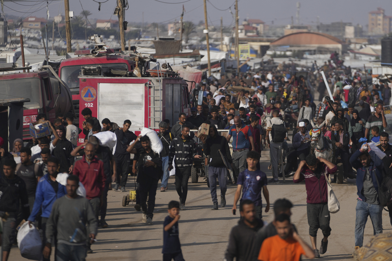 Palestinier bär på nödhjälp från det kontroversiella initiativet Gaza Humanitarian Foundation (GHF). Bilden togs i söndags i Khan Yunis i Gaza. Foto: Abdel Kareem Hana/AP/TT
