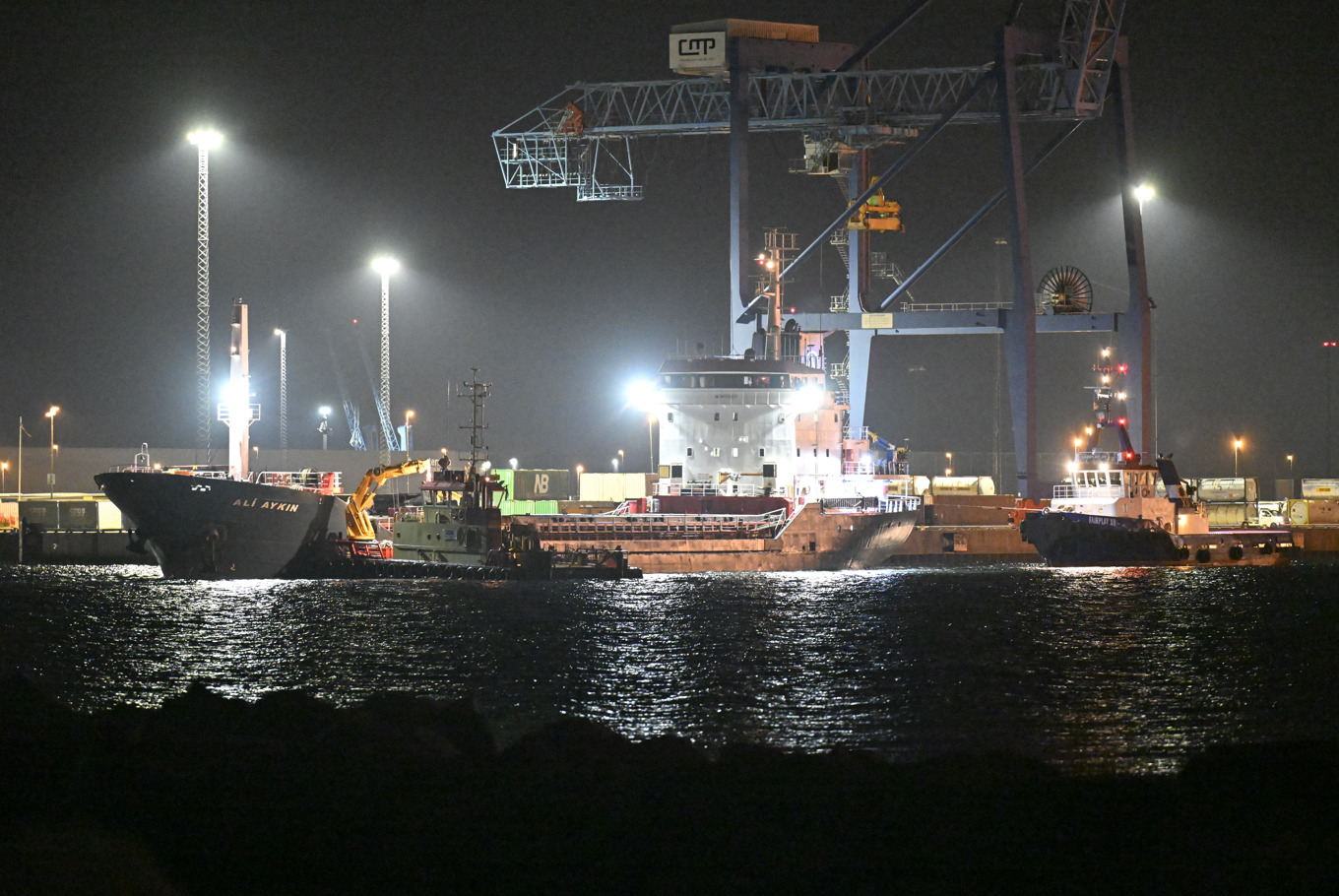 Bulkfartyget Ali Aykin får hjälp av bogserbåtarna Sound Horizon och FairPlay XII in till kaj i hamnen i Malmö natten till torsdagen efter att hon dragits loss från grundet utanför Klagshamn söder om Öresundsbron där hon stått sedan slutet på maj. Foto: Johan Nilsson / TT