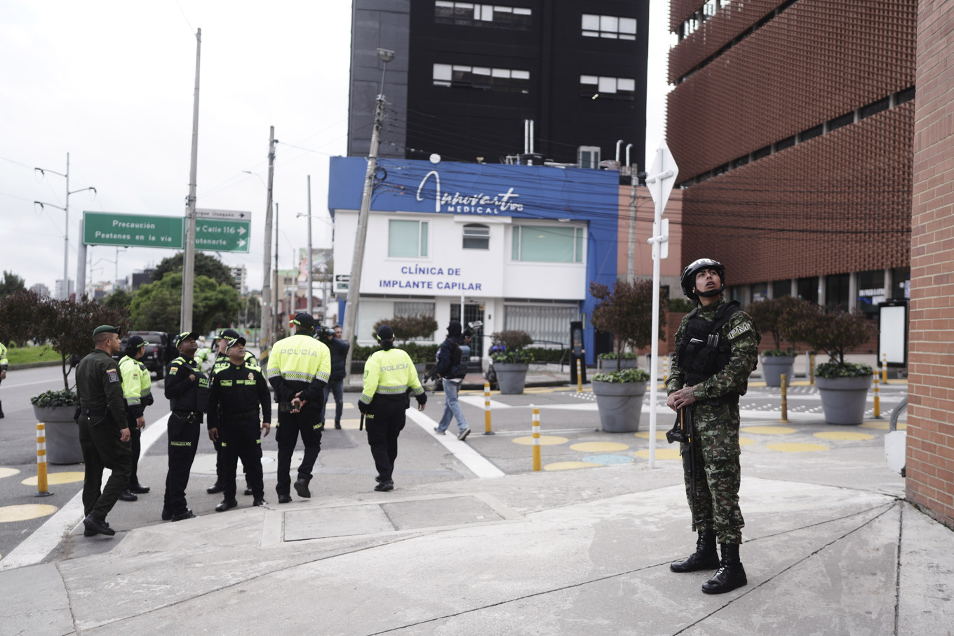 En soldat och poliser utanför sjukhuset i Bogotá där Miguel Uribe vårdas på söndagen. Foto: Ivan Valencia/AP/TT