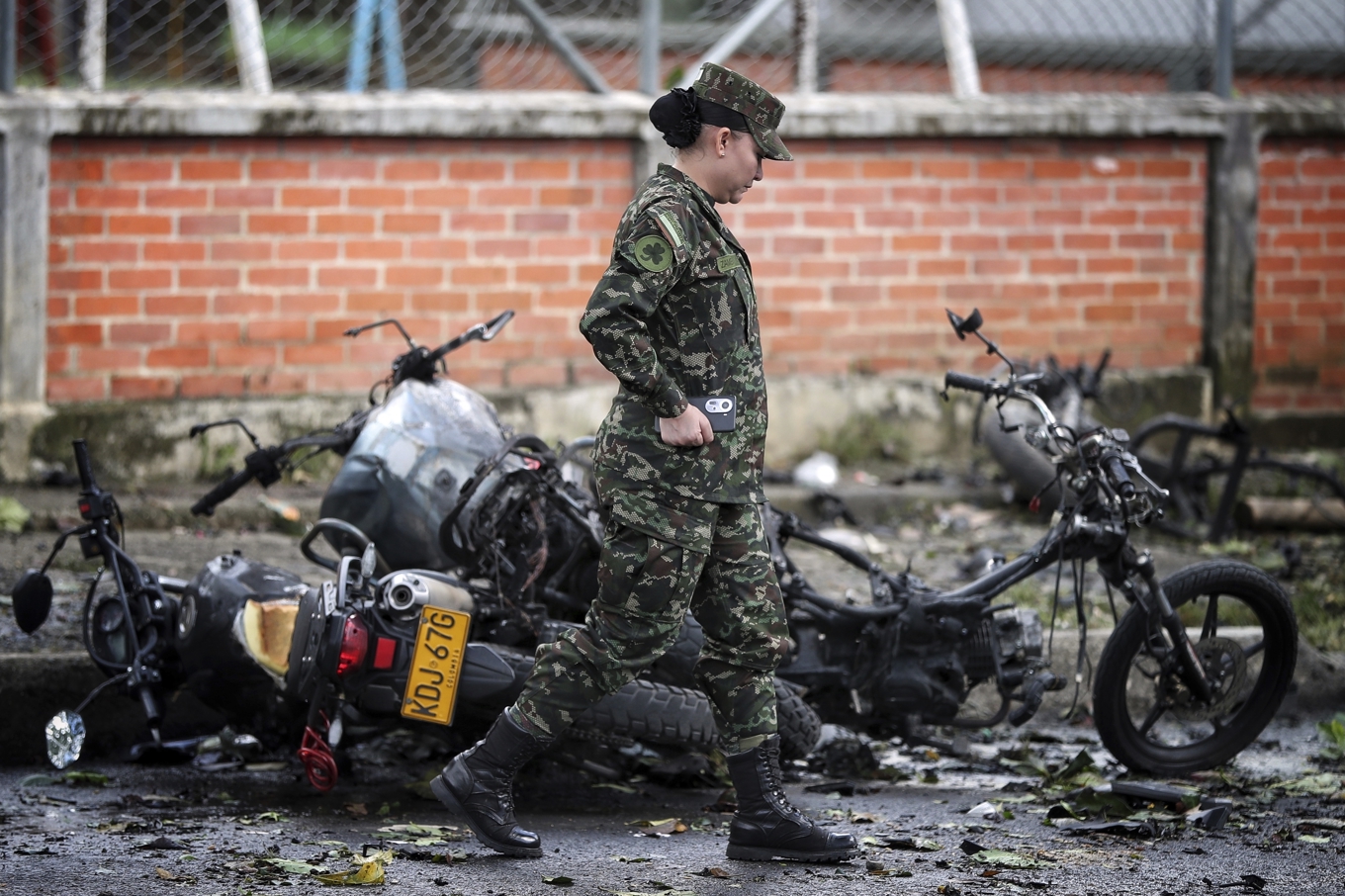 En soldat går förbi en utbränd motorcykel sedan en bomb exploderat i staden Cali i Colombia. Foto: Santiago Saldarriaga/AP/TT
