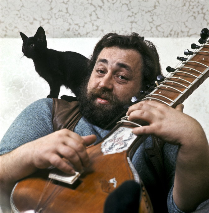 Trubaduren Cornelis Vreeswijk (1937-1987) med en sitar i famnen och sin svarta kattunge på axeln i hemmet. Arkivbild. Foto: Alf Lidman/TT