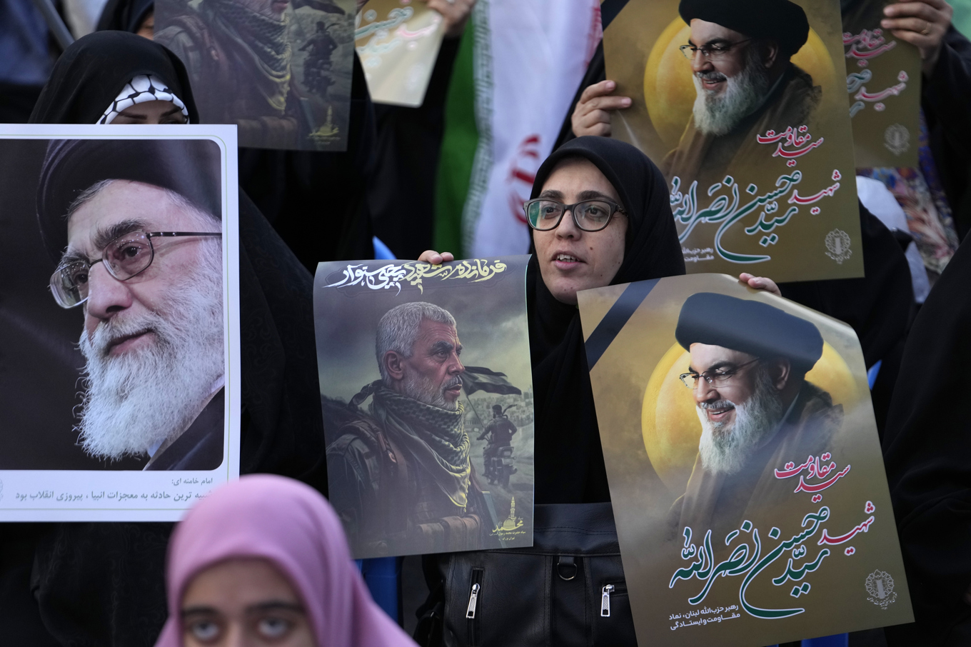 Iranska regimanhängare som håller upp bilder på dödade Hizbollahledaren Hassan Nasrallah, dödade Hamasledaren Yahya Sinwar och Irans högste ledare Ali Khamenei. Foto: Vahid Salemi/AP/TT