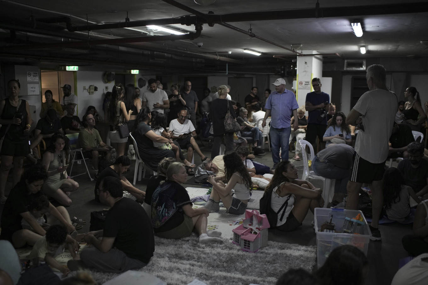 Människor som sökte skydd i Tel Aviv när nya flyglarm ljöd på fredagen. Foto: Leo Correa/AP/TT