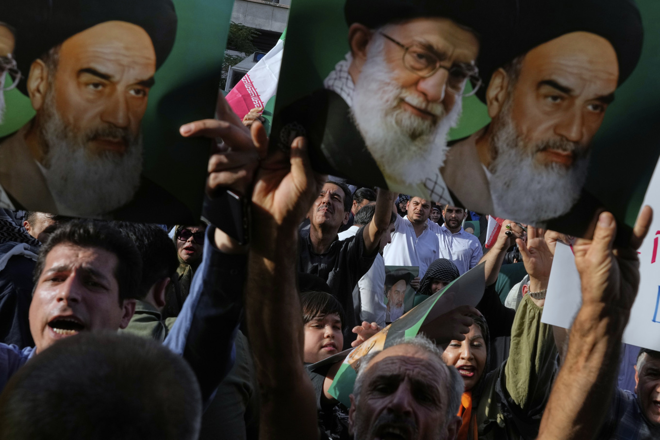 Bilder av Irans högste ledare ayatolla Khamenei och hans företrädare ayatolla Khomeini hålls upp vid en protest i Teheran under söndagen mot västvärldens Iranpolitik. Foto: Vahid Salemi/AP/TT
