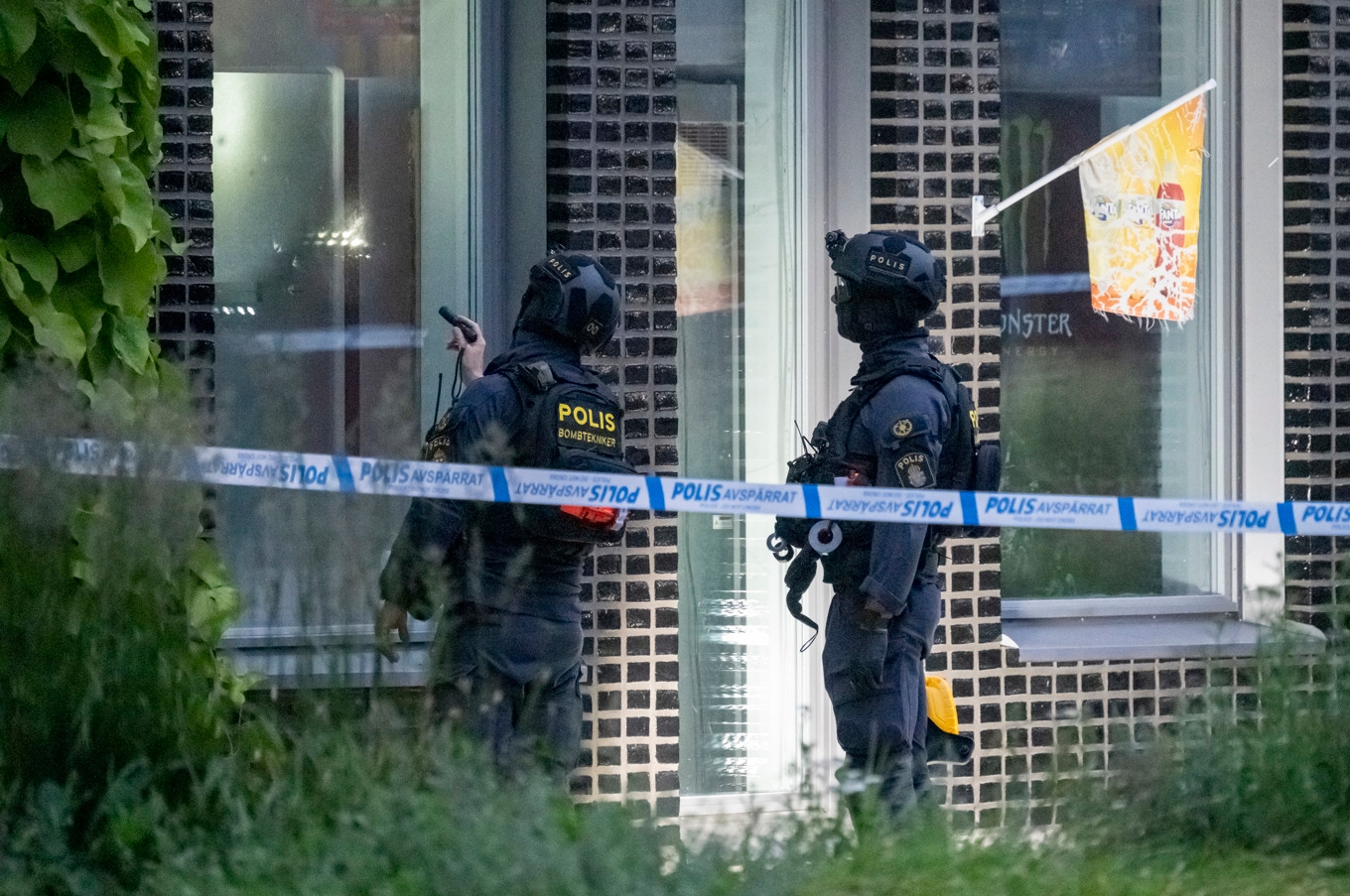 Polisens bombtekniker undersöker skadorna efter larm om en explosion vid en kvartersbutik i ett flerfamiljshus på Industrigatan i Malmö tidigt på måndagsmorgonen. Foto: Johan Nilsson/TT