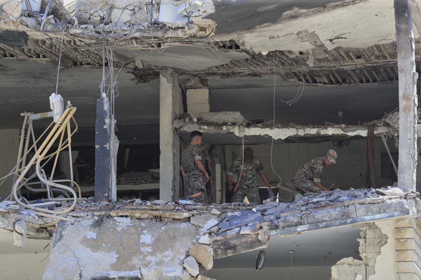 Libanesiska soldater letar igenom en byggnad i staden Nabatiyeh som under fredagen träffades av israelisk eld. Foto: Mohammad Zaatari/AP/TT