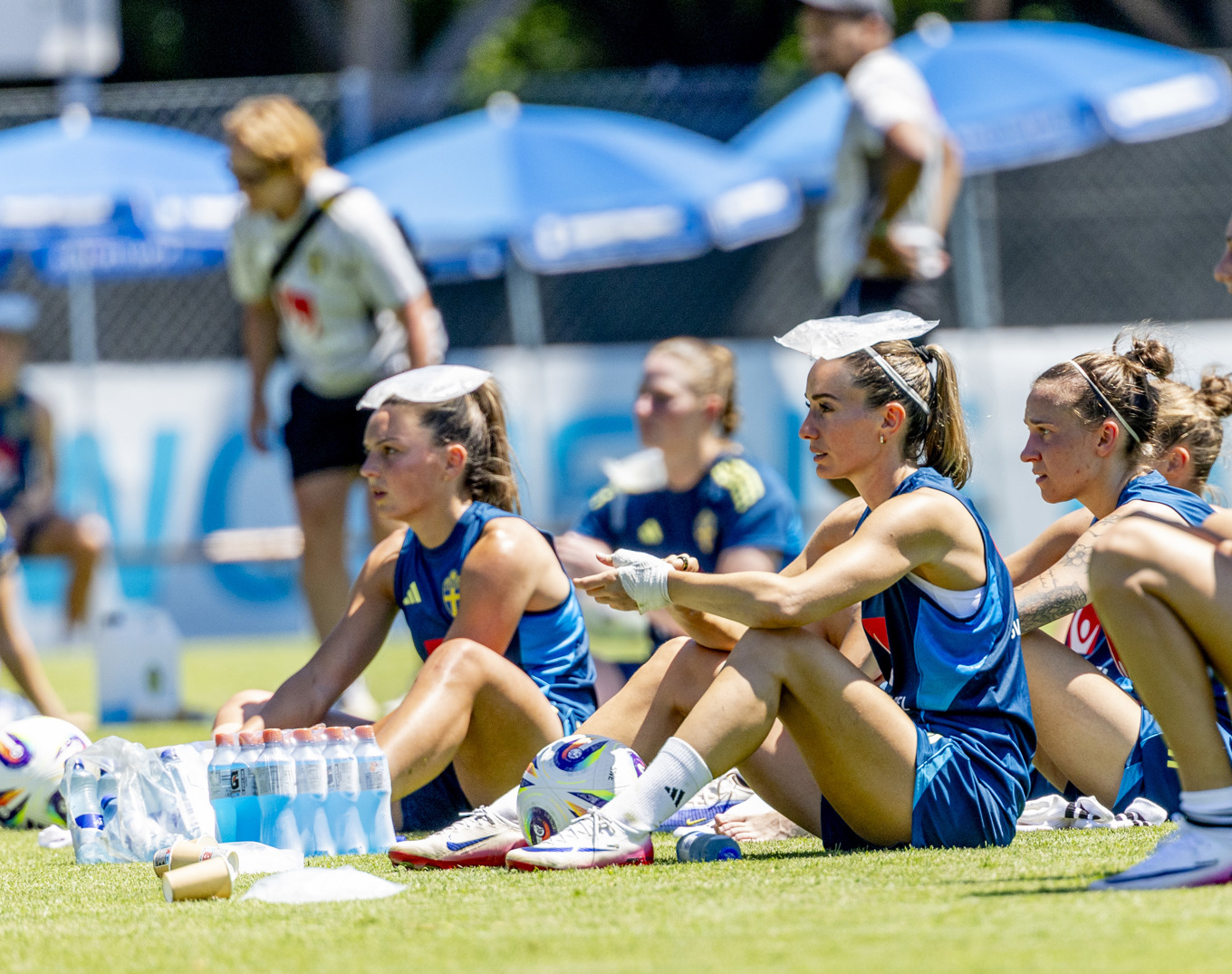 Svenskorna Kosovare Asllani och Johanna Rytting Kaneryd svalkar sig i värmen under första träningen i Schweiz. Foto: Adam Ihse/TT