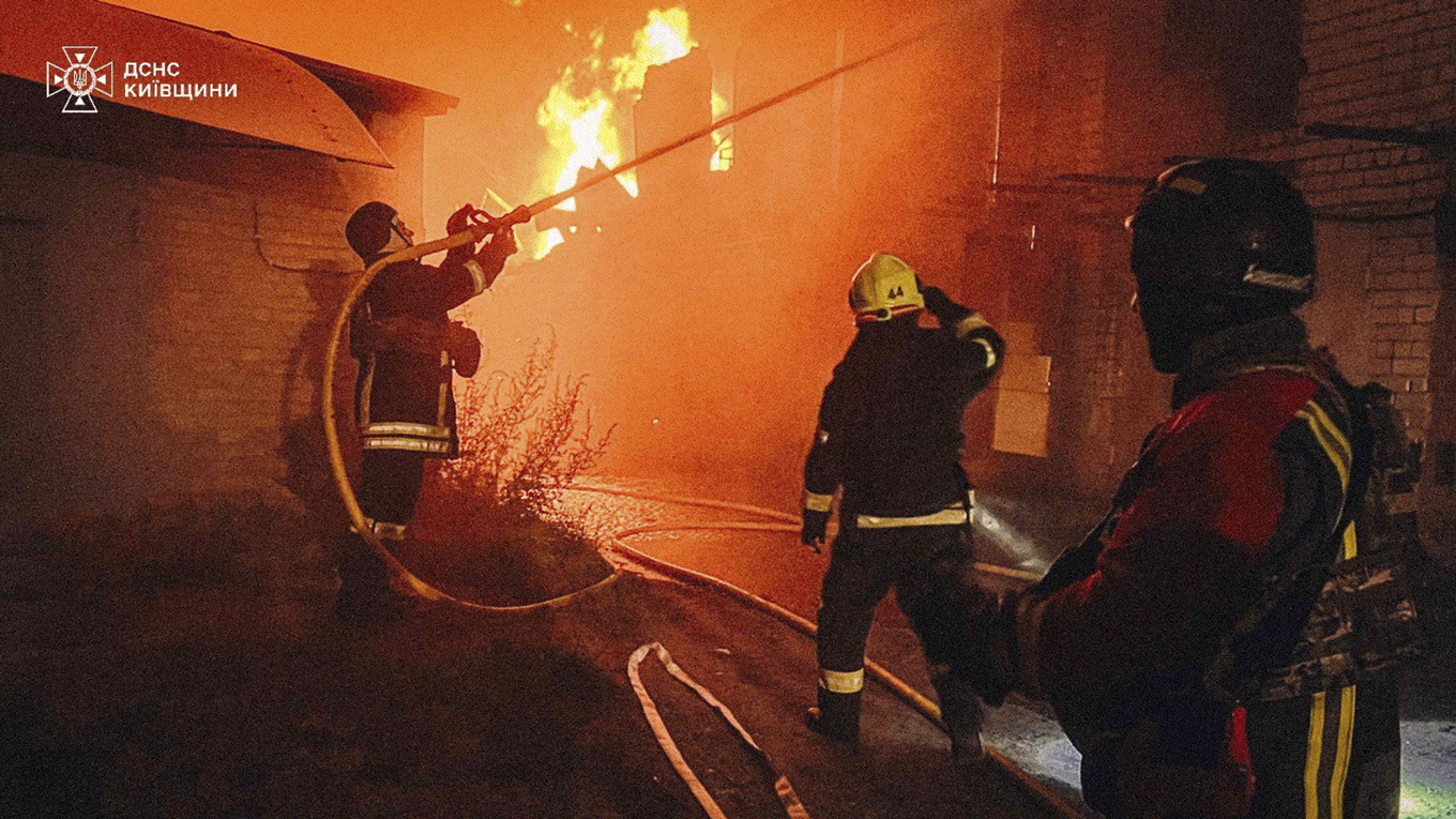 Brandmän jobbar med att släcka bränder strax sydväst utanför huvudstaden efter nattens ryska attacker. Foto: Ukrainas statliga räddningstjänst via AP/TT