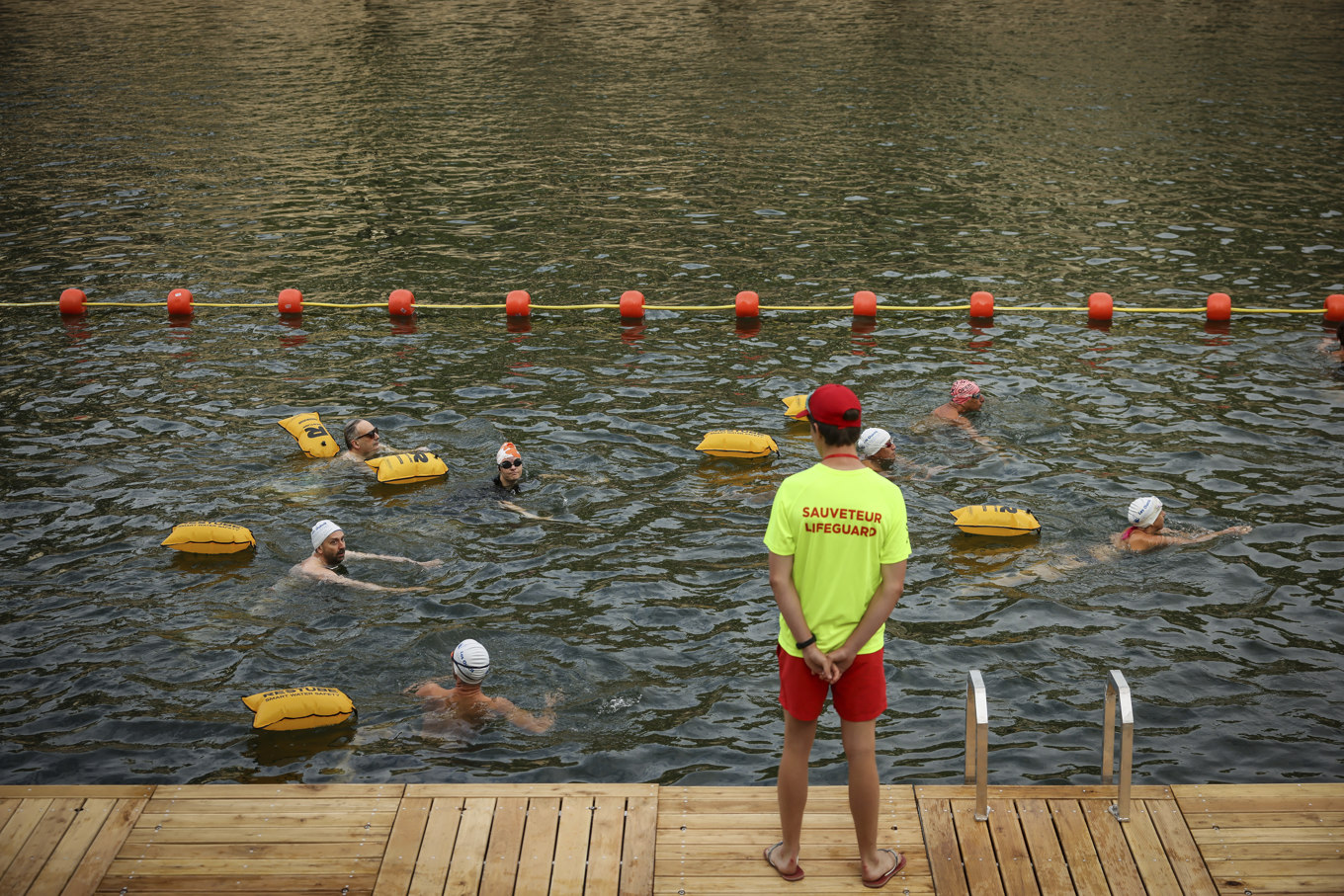 En badvakt håller koll på några av dem som tagit sig ett dopp i Seine. Foto: Thomas Padilla/AP/TT