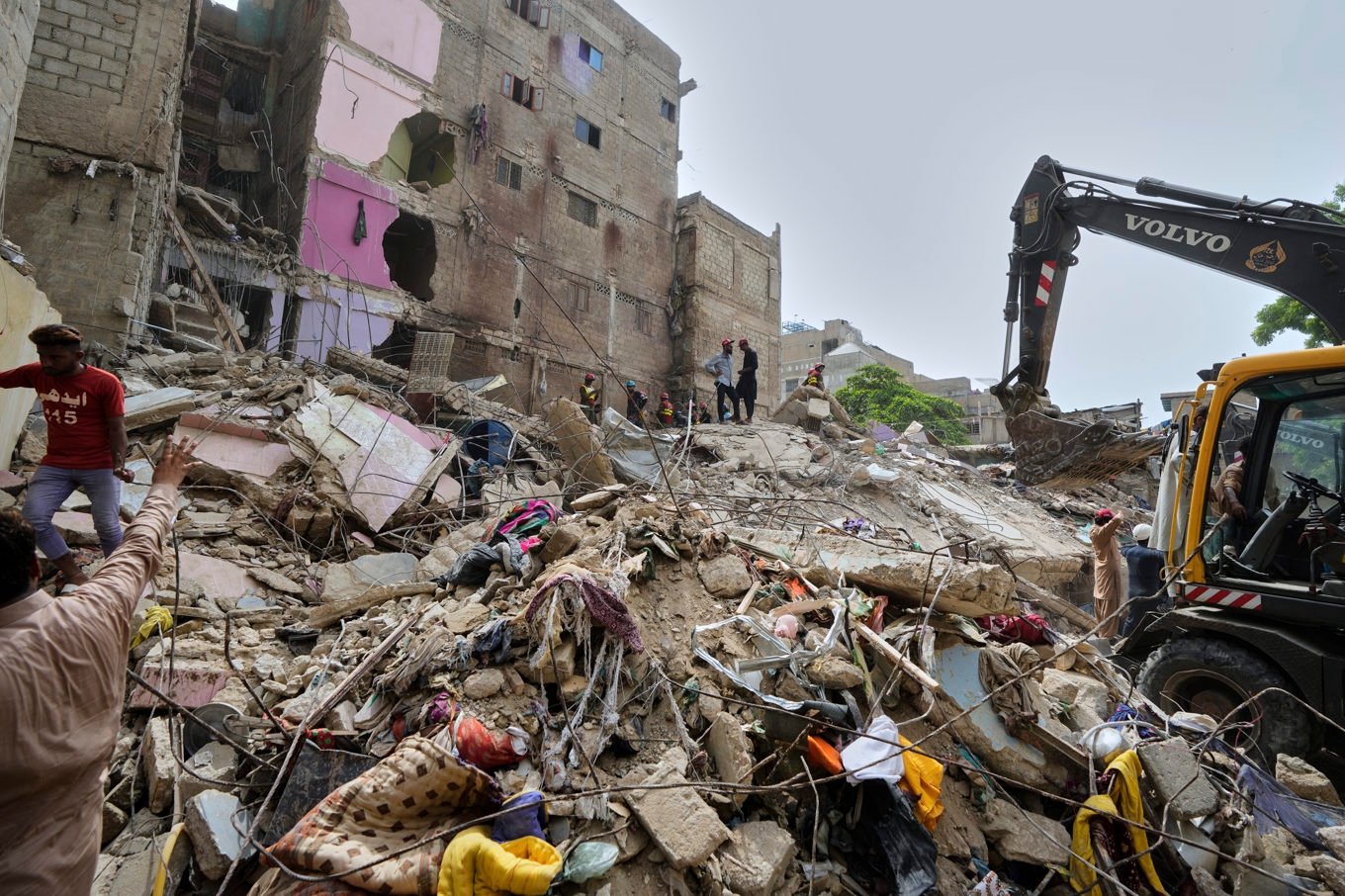 Räddningsmanskap söker igenom resterna av ett kollapsat hus i Karachi i Pakistan. Foto: Fareed Khan/AP/TT