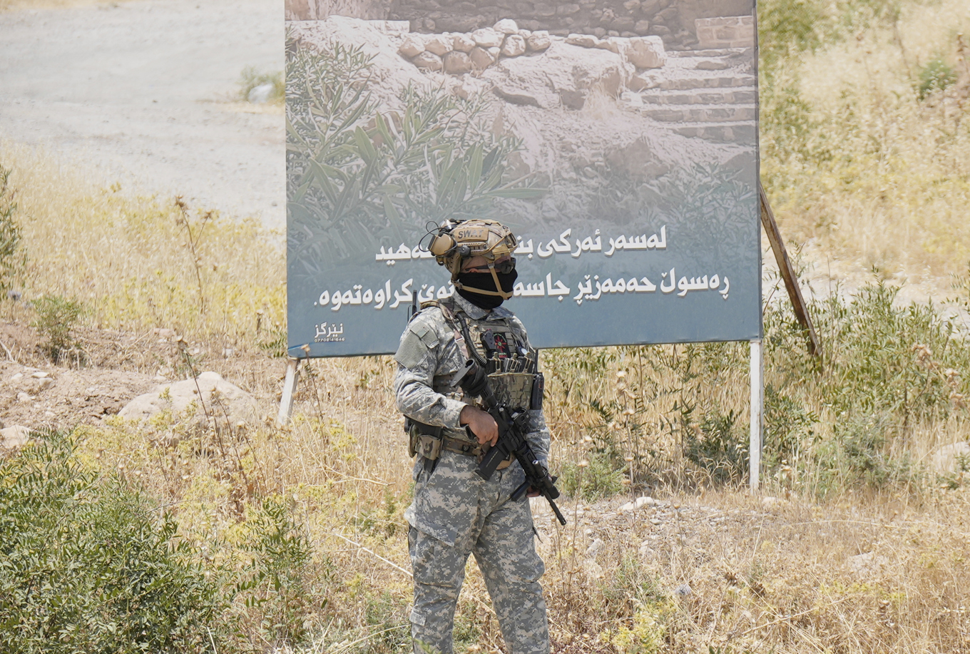 En soldat från den regionala kurdiska administrationen säkrar området i irakiska Kurdistan där den symboliska avväpningen ägde rum. Foto: Hadi Mizban/AP/TT