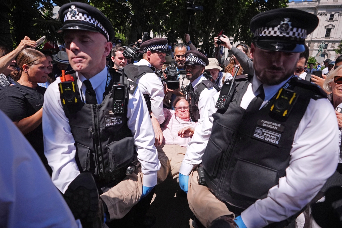 Polisen lyfter bort en demonstrant i London. Foto: James Manning/PA via AP/TT